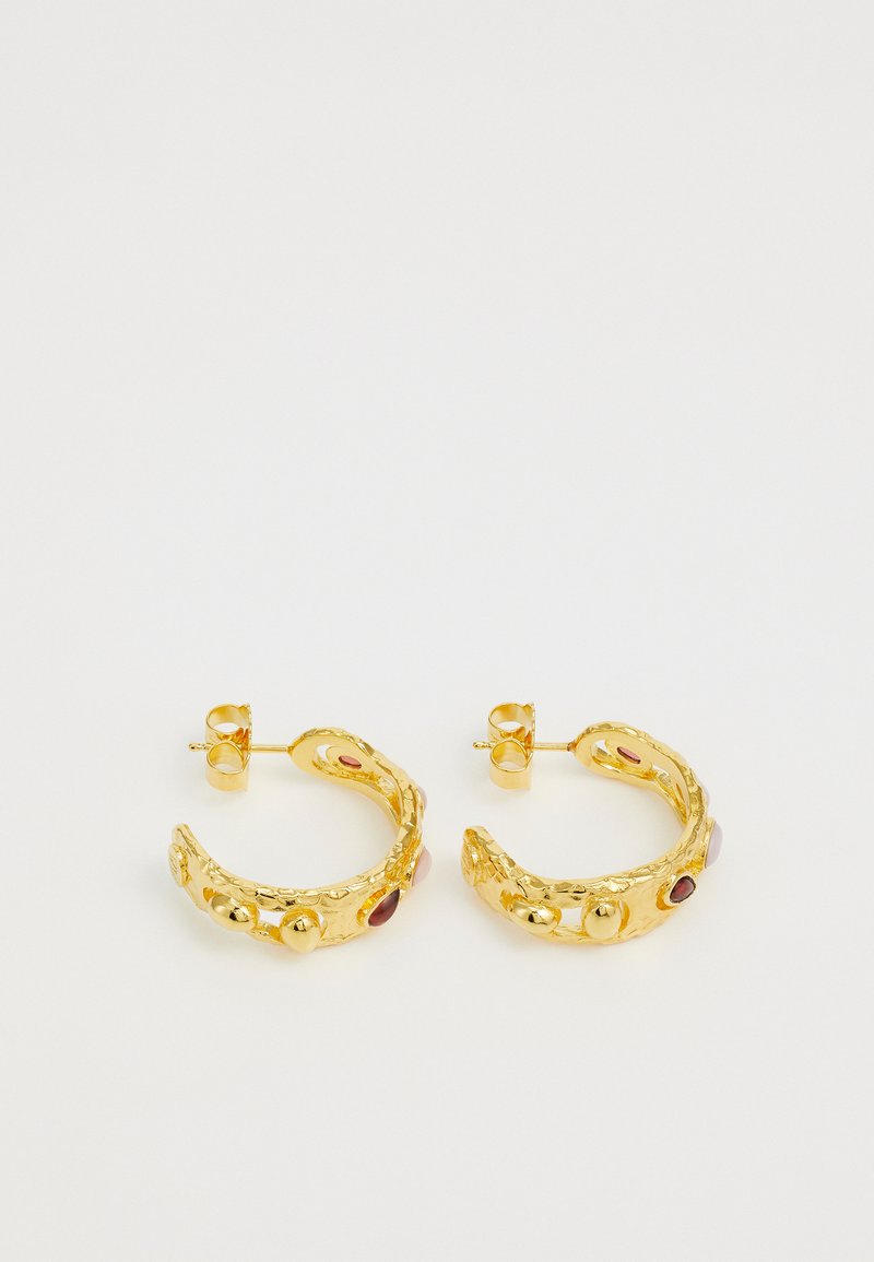 Zelta auskari ar sarežģītu tekstūrētu dizainu, ar dažādu krāsu akmeņiem un spīdīgām detaļām. Apaļa forma ar tapām.