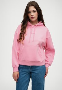 Rosa Kapuzenpullover mit vorderer Kängurutasche, gerippten Bündchen und Saum. Verfügt über eine Kapuze mit Kordelzug und ein minimalistisches Logo auf der Brust.