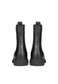 Botines negros de cuero con textura suave, que presentan paneles elásticos en los laterales, una suela de goma gruesa y un detalle de costura limpia.