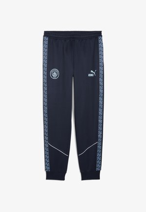 Pantaloni da track navy in materiale sintetico con una striscia laterale a fantasia blu, logo del Manchester City e "KING" in blu chiaro.
