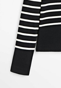 Czarny sweter w paski z szerokimi białymi poziomymi paskami, o ryflowanej fakturze i dopasowanym kroju, z długim rękawem.