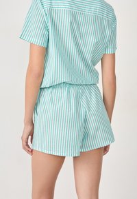 Lichtgewicht, mintgroen en wit gestreept kort setje met korte mouwen. Relaxed fit met elastische tailleband en zijzakken.