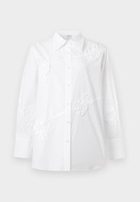 Chemise blanche à manches longues avec col pointu et broderies florales sur la poitrine, les manches et les parties inférieures avant.
