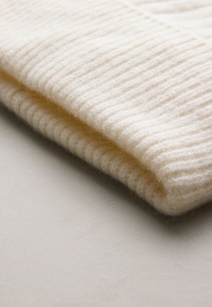 Kremfarvet strikket hue med ribbet tekstur, lavet af blødt uld. Inkluderer en dobbeltkant og en glat finish, velegnet til koldere vejr.