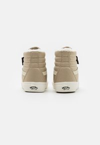 Beige høye sneakers med polstret krage, kremfarget fôr og side stripe detaljer. Har logo på hælen og teksturert kanvasmateriale.