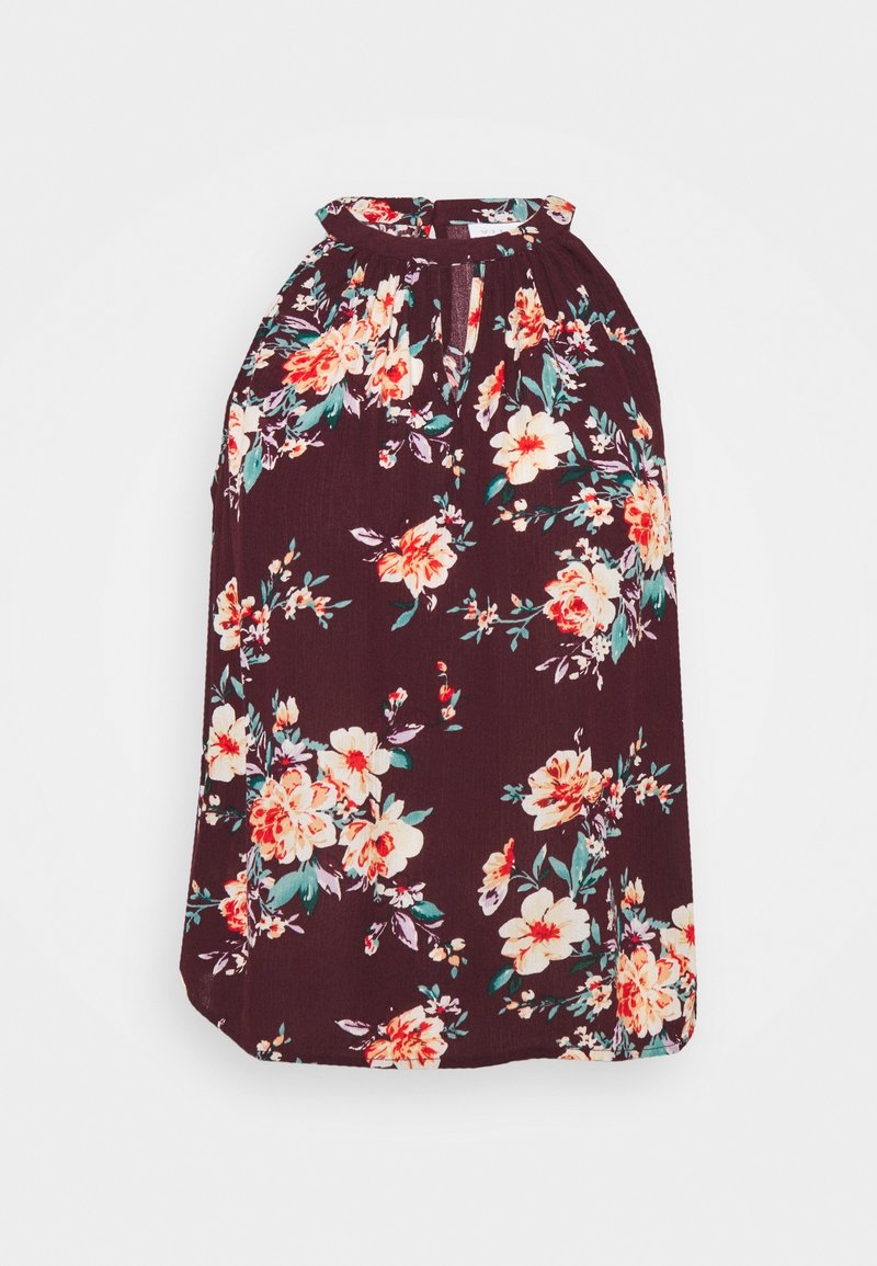 Blouse sans manches d'un violet foncé avec un col haut et un motif floral coloré dans des teintes de crème, de rouge et de vert.