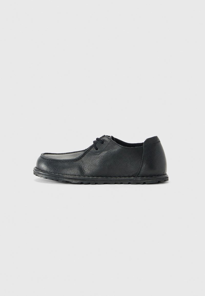 Black leather shoe with a rounded toe, low sides, and a textured finish. Features a simple lacing system and a flexible rubber sole.