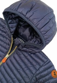 Giacca imbottita blu navy con cappuccio, caratterizzata da cuciture orizzontali, una zip dorata e una toppa in pelle arancione del marchio sul lato sinistro in basso.