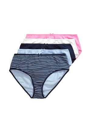 Vrouw met schouderlang blond haar, die een witte beha, marineblauw-wit gestreepte onderkleding en een gedeeltelijk gedragen wit overhemd draagt.