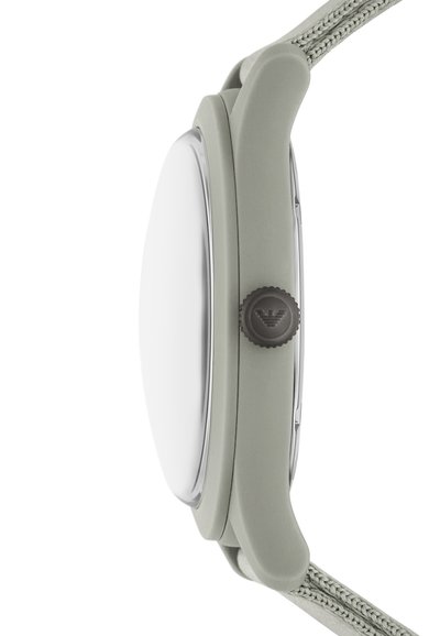 Montre en silicone verte avec un boîtier lisse, une lunette en argent, un cadran en verre rond et un bracelet en tissu texturé. Présente un bouton sombre avec un logo.
