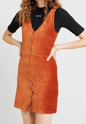 Kordkleid in verbranntem Orange mit taillierter Silhouette, tiefem V-Ausschnitt, Knöpfen vorne und seitlichen Taschen. Strukturierter Stoff, ärmelloses Design.