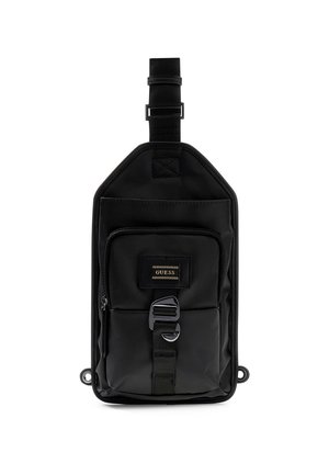 Sac en nylon noir de forme rectangulaire, avec une poche zippée à l'avant, une sangle réglable et un logo en patch doré. Texture lisse, design minimaliste.