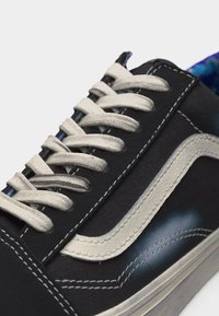 Ασπρόμαυρο αθλητικό παπούτσι με λευκά κορδόνια και ραφές, με λευκή δερμάτινη πλαϊνή ρίγα και παχιά λαστιχένια σόλα.