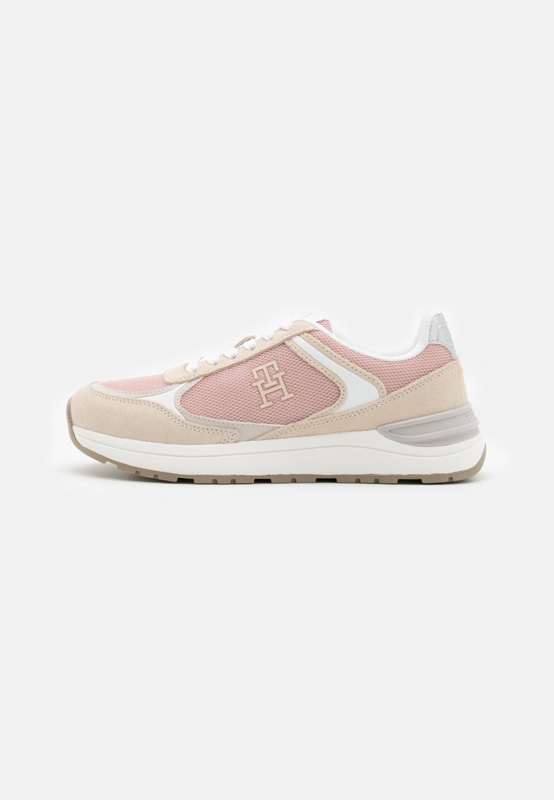 Zapatillas de deporte rosas y beige con parte superior de malla, acentos de ante, detalles blancos y suela de goma texturizada. Presenta un logo prominente en el lateral.