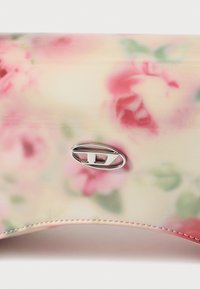 Clutch-taske med blomstertryk i glat, blankt syntetisk materiale, med en sølv oval hardware-detalje og pink syninger langs kanterne.