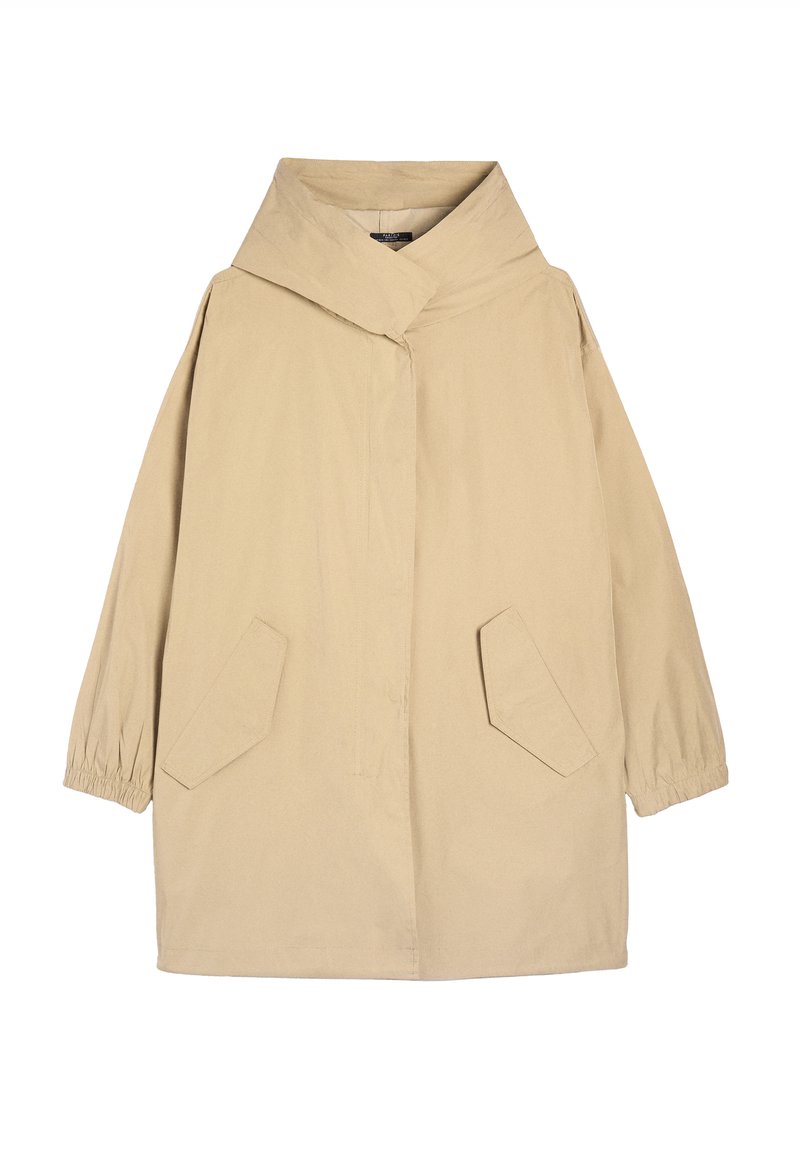 Veste oversize beige avec un col montant, des poignets élastiques et deux poches avant angulaires. Fabriquée en tissu lisse et léger.