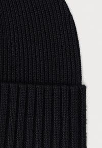 Black knitted beanie with a ribbed texture, featuring a fold-over cuff and a soft, dense fabric for warmth and comfort.