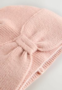 Beanie roz tricotat cu un finisaj texturat, având un detaliu mare sub formă de fundiță în partea din față și o margine striată pentru o potrivire confortabilă.
