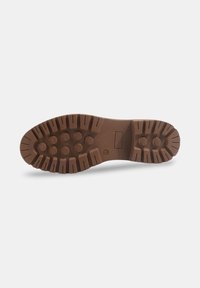 Semelle de botte en caoutchouc marron avec des motifs de relief profonds, des grips circulaires et un emblème rectangulaire. Surface texturée pour une traction améliorée.
