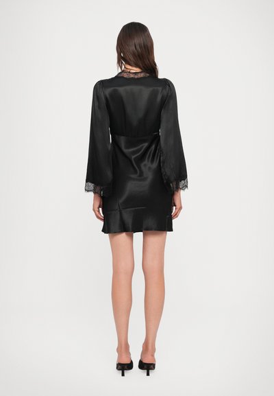Black satin dress with long, sheer bell sleeves and a lace-trimmed neckline. Fitted silhouette with a flared hem and smooth texture.