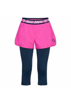 Shorts de sport roses portés sur des leggings bleu marine trois-quarts avec une ceinture élastique de marque et un petit logo sur la cuisse gauche.