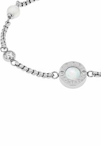 Pulsera de cadena de plata con un charm redondo con texto grabado, una piedra opalescente y cristales transparentes alternando con cuentas brillantes.