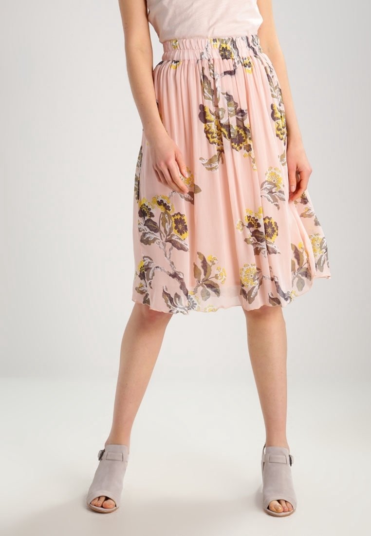 Jupe midi fleurie rose en tissu léger avec une taille élastique froncée. Présente des motifs floraux jaunes et marron.