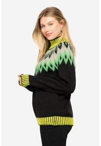 Schwarzer Strickpullover mit hohem Kragen, grünen und gelben geometrischen Mustern sowie gerippten Bündchen und Saum.