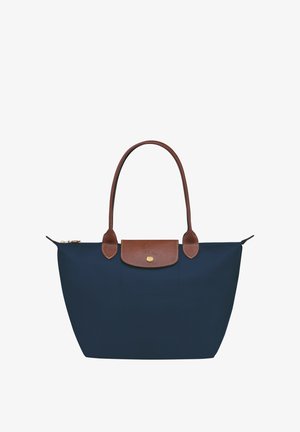 Navy blue tote bag with brown leather accents, two sturdy handles, and a zippered closure. Smooth nylon material and a flat base.