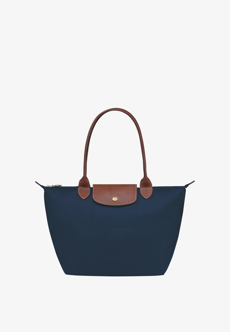 Navy blue tote bag with brown leather accents, two sturdy handles, and a zippered closure. Smooth nylon material and a flat base.