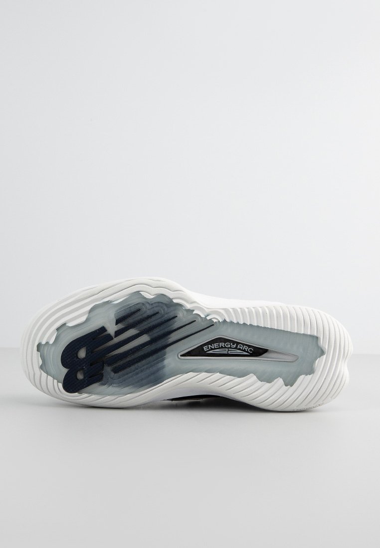 La semelle de la sneaker blanche présente un design en caoutchouc texturé avec des accents bleus et un logo "ENERGY ARC" visible. Sa forme courbée est ornée de motifs striés.