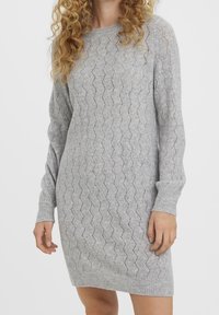 Robe tricotée grise avec un motif en zigzag, des manches longues et un ourlet côtelé. Fabriquée dans un matériau doux et texturé pour le confort.