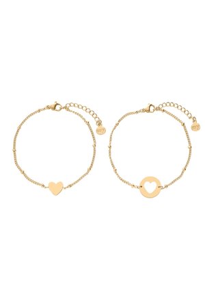 Deux bracelets délicats en chaîne d'or avec fermoirs réglables, l'un avec un pendentif cœur solide, l'autre un pendentif rond avec découpe en forme de cœur.
