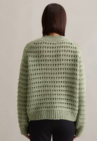 Hellgrüner gestrickter Pullover mit einem strukturierten, offenen Netzmuster, geripptem Saum und Bündchen sowie einem Rundhalsausschnitt.