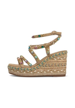 Sandale à talon compensé beige avec plateforme tressée, bride à la cheville et ornements multicolores en pierres et clous dorés sur plusieurs brides.