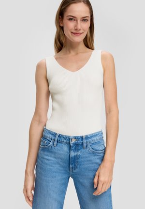 Witte geribde tanktop met een V-hals, gecombineerd met lichtblauwe denim jeans met vijf zakken en een klassieke knoopsluiting.