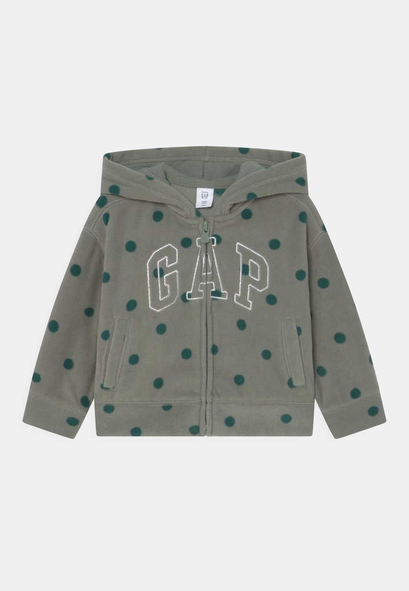 Sweat à capuche en polaire verte avec des pois vert foncé, fermeture éclair à l'avant, deux poches, et "GAP" brodé en blanc sur la poitrine.