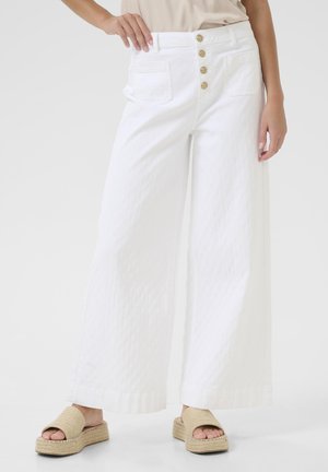 Un pantalon large blanc en tissu texturé, taille haute avec cinq boutons dorés et deux poches arrière. Fini avec un ourlet.