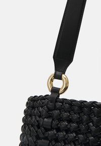 Czarna pleciona torebka z teksturowanym korpusem, gładkim skórzanym paskiem i złotym okrągłym elementem ozdobnym.