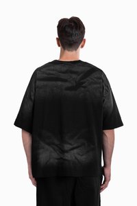 Musthave suuruse must t-särk lühikeste varrukatega, millel on veidi tekstureeritud viimistlus ja tagasi peenelt pleekinud muster.