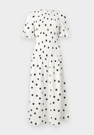 Λευκό μεσοφόρεμα με μαύρες πουά, κοντά φουσκωτά μανίκια, μπούστο με σφηκοφωλιά και φούστα με πιέτες.