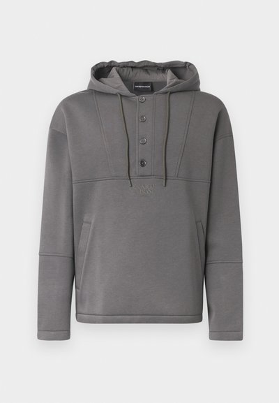 Hanorac gri dintr-un material moale, cu un buzunar frontal, o clapetă cu patru nasturi, glugă cu șnur și logo reliefat pe piept.