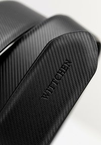 Doplňkový pásek z černého uhlíkového vlákna s texturovaným herringbone vzorem a embosovaným brandingem "WITTCHEN". Hladký a elegantní design.