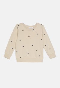 Sweatshirt beige clair avec motif de cœur gris, poignets et ourlet côtelés, encolure ronde et texture douce. Design décontracté adapté aux superpositions.