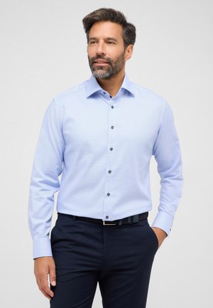 Himmelblaues Langarmhemd mit dezentem Muster, knopfleiste und dunklen Knöpfen. Tragen Sie es zu einer dunklen Hose und einem strukturierten Gürtel.
