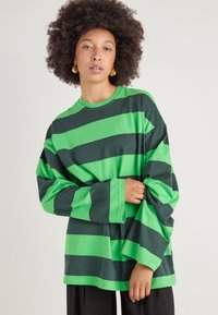 Langærmet t-shirt med vekslende grønne og mørkegrønne striber, lavet af bomuld, med en afslappet pasform og rund halsudskæring.