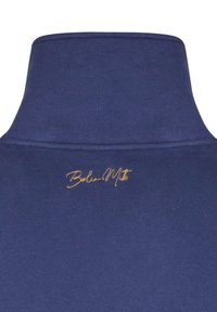 Felpa con collo alto di colore blu navy, caratterizzata da una texture morbida e un logo ricamato in oro che riporta la scritta "Berlin M." sul lato sinistro.