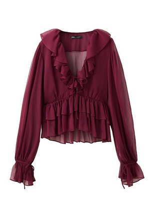 Blouse bordeaux transparente à manches longues avec col en V volanté, volants à la taille et poignets cintrés avec liens.