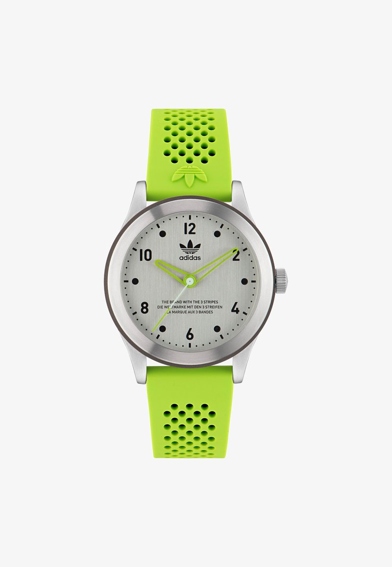 Hõbedane roostevabast terasest kell rohelise perforatsiooniga silikoonrihmaga. Hall nägu mustade tundide markerite ja roheliste kätega. Omab Adidas logo.