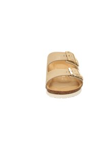 Beige slide sandal med två justerbara remmar och silverfärgad spännen, med en korkfotbädd och vit gummisula. Enkelt design och textur.